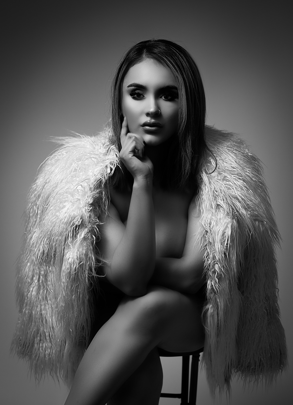 black and white photoshoot with a fur jacket in a sitting bold and sexy pose with dramatic lighting and very talented high end skin retouching and editing removing all blemish and stretch marks. Aly works in modesto and san francisco