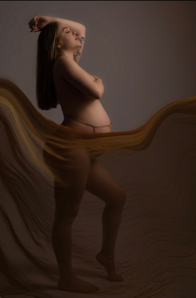 this is the most artistic and natural pregnancy photography with mama being nude and wearing a belly jewelry with flowing fabric to cover and keep her in a gorgeous natural pose. this photo was taken by the best luxury photographer in all of san fran