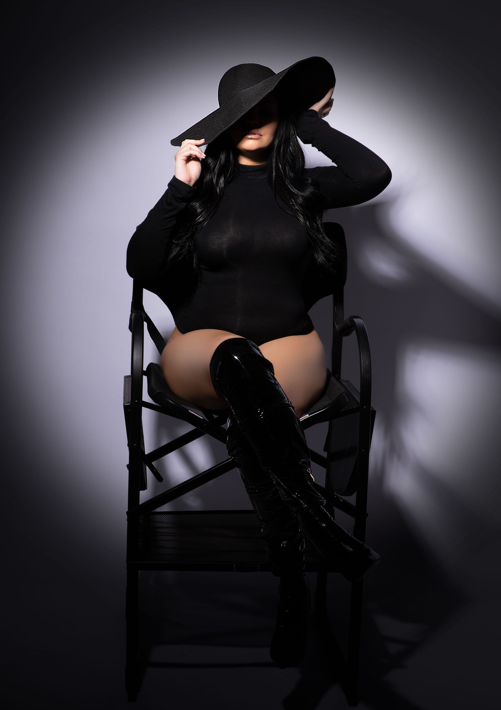 conservative boudoir photoshoot with a black long sleeve turtleneck bodysuit and a black hair covering face for a mysterious and elegant pose taken by Modesto luxury photographer aly incardona who shoots all things glamour